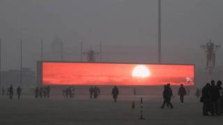 Beijing Citizens, Shrouded In Pollution, Flock To Giant Screens To View Artificial Sunrise