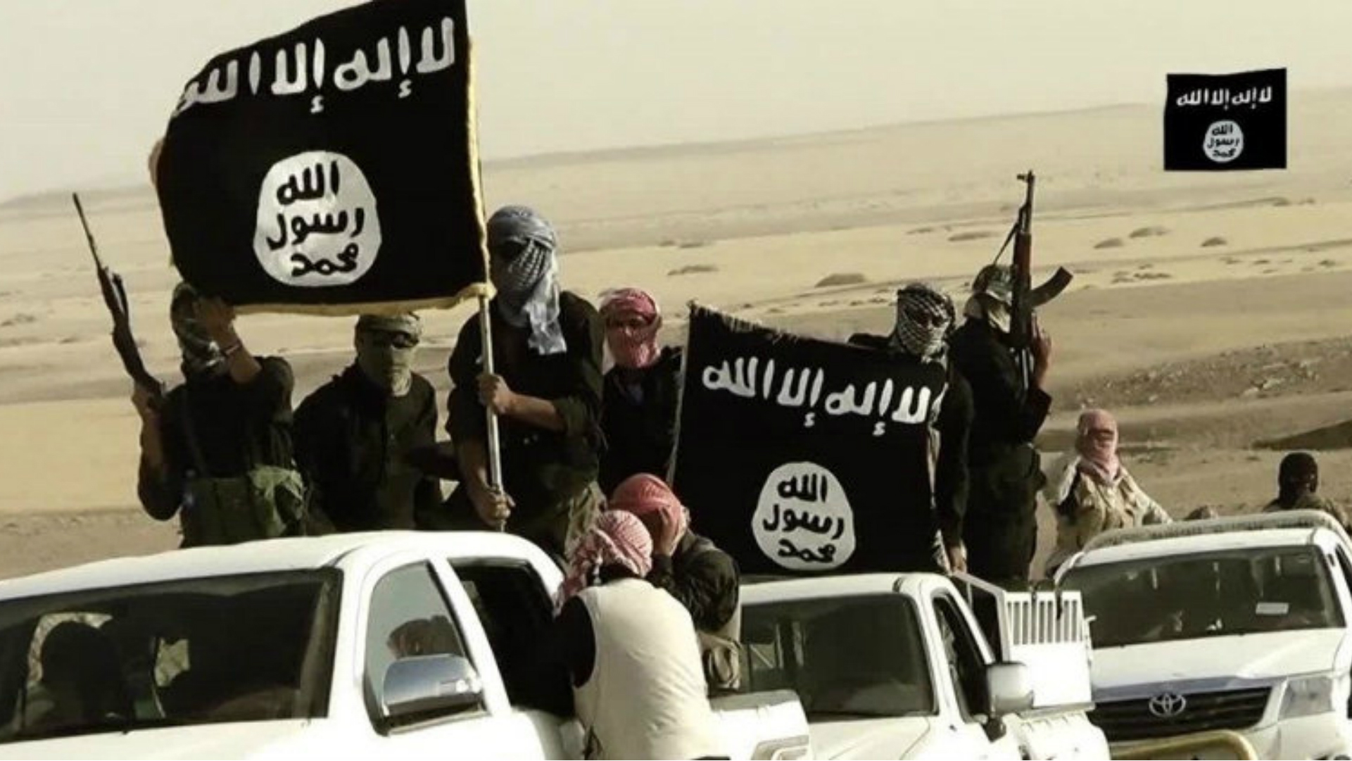 Террористы на фоне флага игил. Флаг группировки ИГИЛ. Флаг Исламского государство ИГИЛ. Знак ИГИЛ.